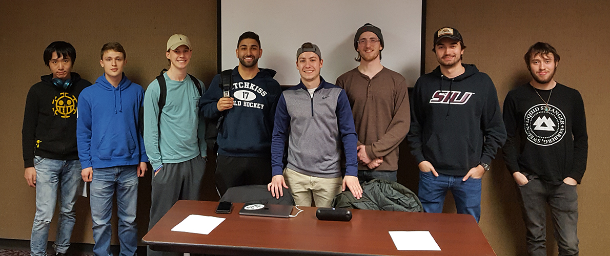 photo of students standing behind a table