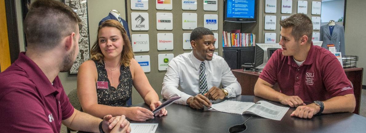 SIU business students discuss around a round table